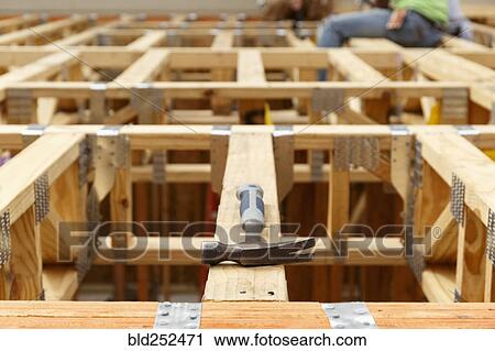 Stock Image - Hammer on the roof at construction site. Fotosearch