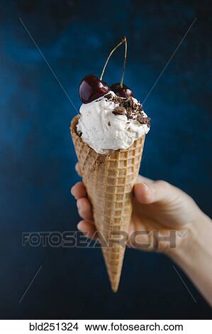 Hand holding ice cream cone with cherries View Large Photo Image Picture - Hand holding ice cream cone with cherries. Fotosearch