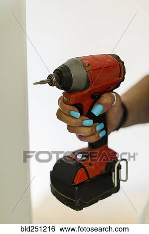 Stock Photograph - Hand of black woman holding drill. Fotosearch