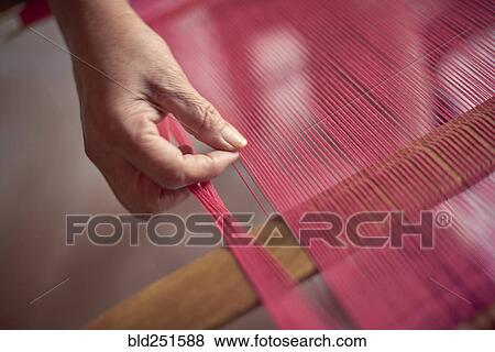 Stock Photo - Hand of Hispanic woman weaving fabric on loom. Fotosearch