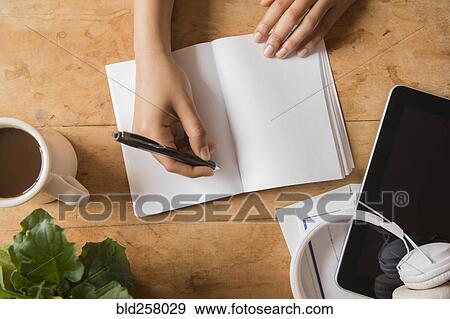 Stock Photo - Hands of African American woman writing in journal. Fotosearch