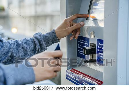 Stock Photo - Hands of Black man paying at kiosk with credit card. Fotosearch