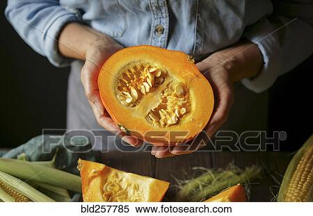 Stock Photography - Hands of Caucasian woman showing sliced squash. Fotosearch