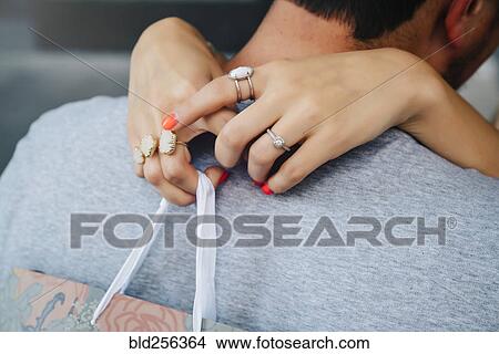 Picture - Hands of Caucasian woman wearing rings hugging man. Fotosearch
