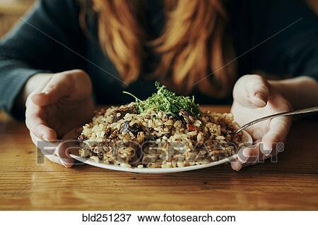 Stock Photo - Hands of woman holding a plate of rice. Fotosearch