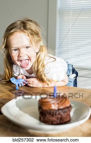 Happy Caucasian girl near birthday cupcake View Large Photo Image Stock Image - Happy Caucasian girl near birthday cupcake. Fotosearch
