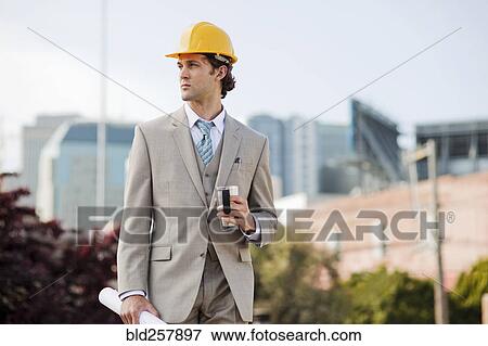 Stock Photo - Hispanic businessman drinking coffee and carrying blue1int outdoors. Fotosearch