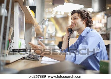 Stock Photo - Hispanic businessman talking on telephone. Fotosearch