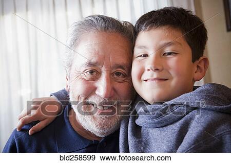 Stock Photo - Hispanic grandfather and grandson hugging. Fotosearch