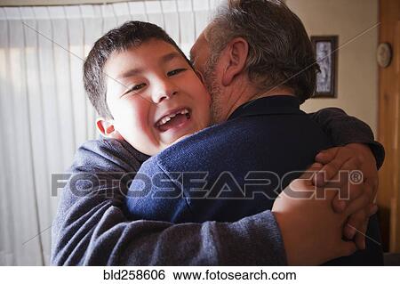Stock Photograph - Hispanic grandfather hugging grandson. Fotosearch