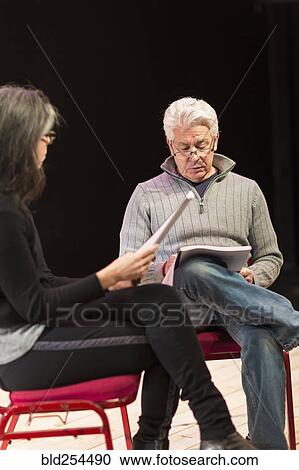 Hispanic man and woman reading scripts on theater stage View Large Photo Image Stock Image - Hispanic man and woman reading scripts on theater stage. Fotosearch