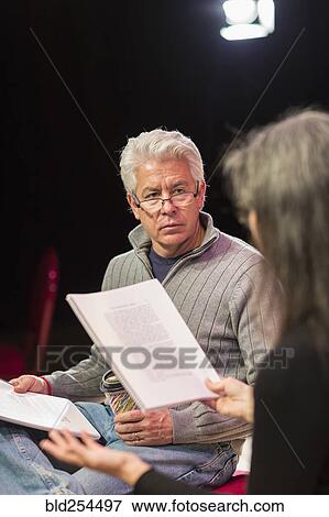 Stock Photo - Hispanic man and woman reading scripts in theater. Fotosearch