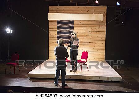Stock Photo - Hispanic man and woman reading scripts on theater stage. Fotosearch
