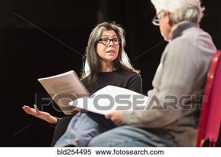 Stock Photography - Hispanic man and woman reading scripts on theater stage. Fotosearch