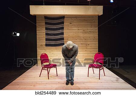 Stock Photo - Hispanic man bowing on theater stage. Fotosearch