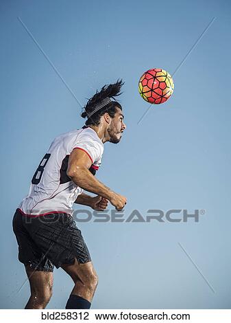Hispanic man heading soccer ball View Large Photo Image Stock Image - Hispanic man heading soccer ball. Fotosearch
