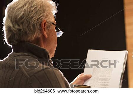 Stock Photograph - Hispanic man reading script in theater. Fotosearch