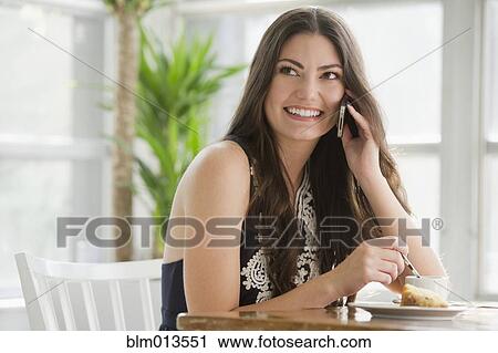 Hispanic woman drinking coffee and talking on cell phone View Large Photo Image Stock Image - Hispanic woman drinking coffee and talking on cell phone. Fotosearch