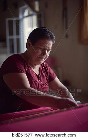 Hispanic woman weaving fabric on loom View Large Photo Image Stock Photo - Hispanic woman weaving fabric on loom. Fotosearch