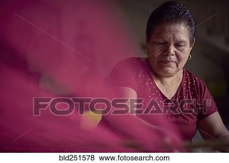 Hispanic woman weaving fabric on loom View Large Photo Image Stock Photo - Hispanic woman weaving fabric on loom. Fotosearch