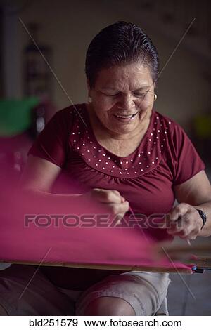 Hispanic woman weaving fabric on loom View Large Photo Image Stock Photo - Hispanic woman weaving fabric on loom. Fotosearch