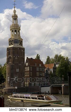 Picture - Historical landmark and tour boat in Amsterdam. Fotosearch