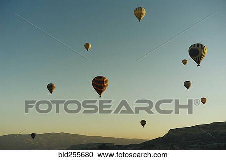 Stock Image - Hot air balloons flying at sunset. Fotosearch
