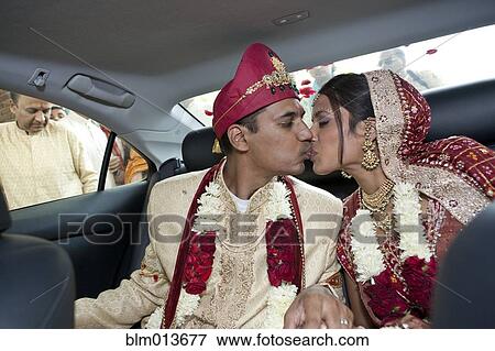 Indian bride and groom in traditional clothing kissing in car View Large Photo Image Stock Photo - Indian bride and groom in traditional clothing kissing in car. Fotosearch