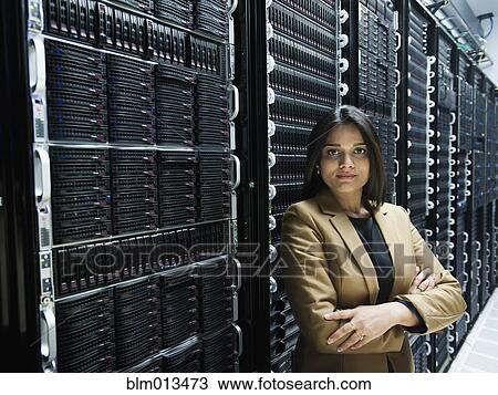 Stock Image - Indian businesswoman standing in server room. Fotosearch