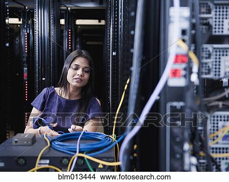 Picture - Indian businesswoman working in server room. Fotosearch