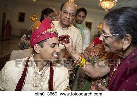 Indian woman marking groom's face View Large Photo Image Stock Photo - Indian woman marking groom's face. Fotosearch