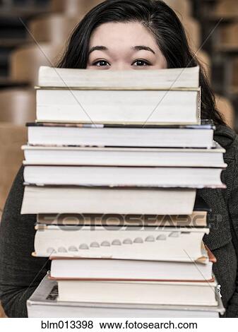 Stock Photo - Korean student holding stack of books. Fotosearch