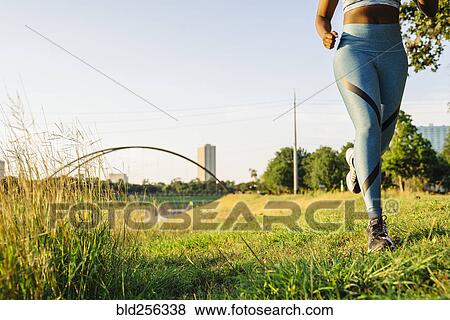 Legs of mixed race woman running in grass near waterfront View Large Photo Image Stock Photo - Legs of mixed race woman running in grass near waterfront. Fotosearch