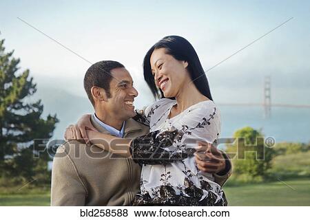 Stock Photo - Man carrying woman at park. Fotosearch