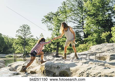 Man helping woman crossing river View Large Photo Image Stock Image - Man helping woman crossing river. Fotosearch