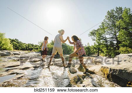 Man helping woman crossing river View Large Photo Image Stock Photo - Man helping woman crossing river. Fotosearch