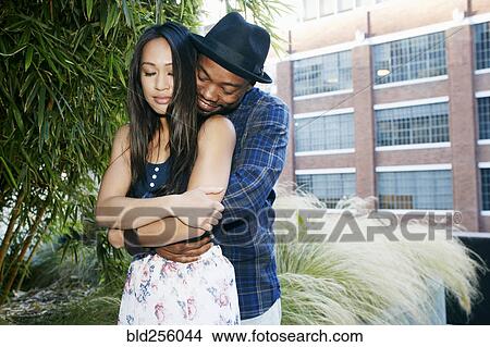 Man hugging woman near foliage View Large Photo Image Picture - Man hugging woman near foliage. Fotosearch