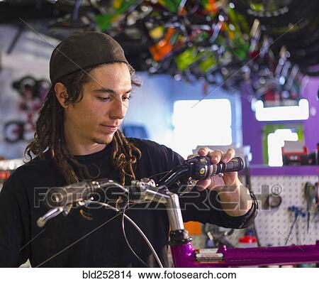 Picture - Man repairing bicycle in shop. Fotosearch