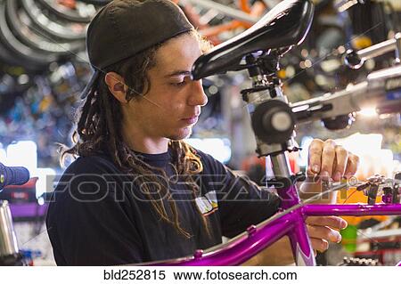 Stock Photography - Man repairing bicycle in shop. Fotosearch