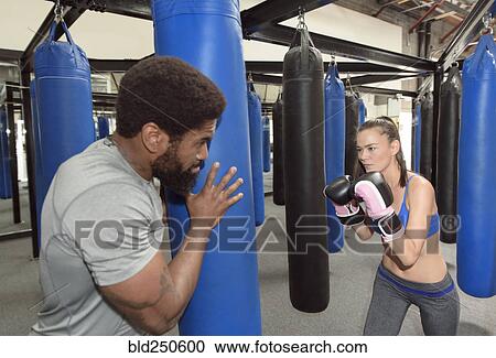 Man training woman using punching bag View Large Photo Image Stock Image - Man training woman using punching bag. Fotosearch