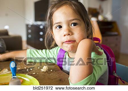 Messy mixed race girl eating food and wearing backpack at table View Large Photo Image Stock Image - Messy mixed race girl eating food and wearing backpack at table. Fotosearch