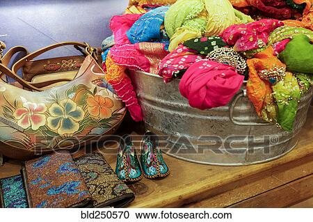 Stock Image - Metal basket of fabric on table in store. Fotosearch
