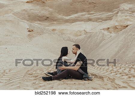Stock Photo - Middle Eastern couple cuddling in desert. Fotosearch
