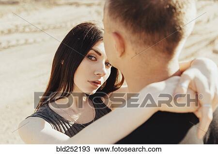 Stock Image - Middle Eastern couple hugging in desert. Fotosearch