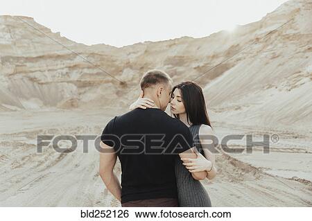 Stock Photograph - Middle Eastern couple hugging in desert. Fotosearch