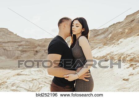 Stock Photograph - Middle Eastern couple hugging in desert. Fotosearch