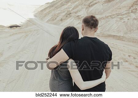 Picture - Middle Eastern couple hugging in the desert. Fotosearch