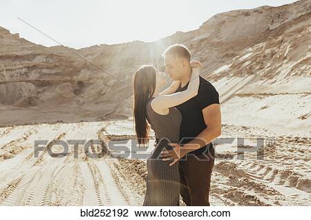 Stock Image - Middle Eastern couple kissing in desert. Fotosearch