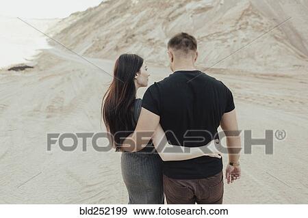 Stock Photo - Middle Eastern couple walking in desert. Fotosearch