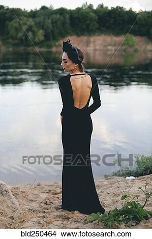Middle Eastern woman wearing black dress near lake View Large Photo Image Picture - Middle Eastern woman wearing black dress near lake. Fotosearch